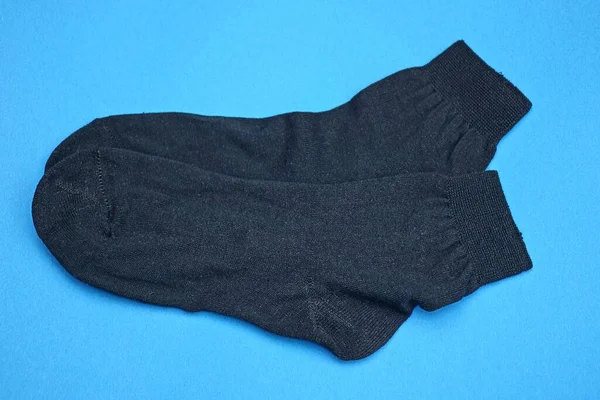 Dvě Černé Tkaniny Ponožky Leží Modrém Stole — Stock fotografie