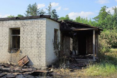 Yeşil çimenlikteki bir yangından sonra beyaz bir tuğlanın parçası evi yok etti.
