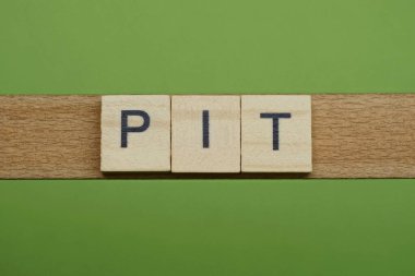 yeşil arkaplanda tahta kare harflerden oluşan gri kelime çukuru