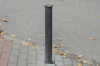 Siyah demir bir çit dışarıda, gri kaldırımda.