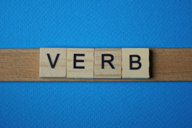 mavi arkaplanda siyah yazı tipi olan küçük kare ahşap harfli gri kelime fiili