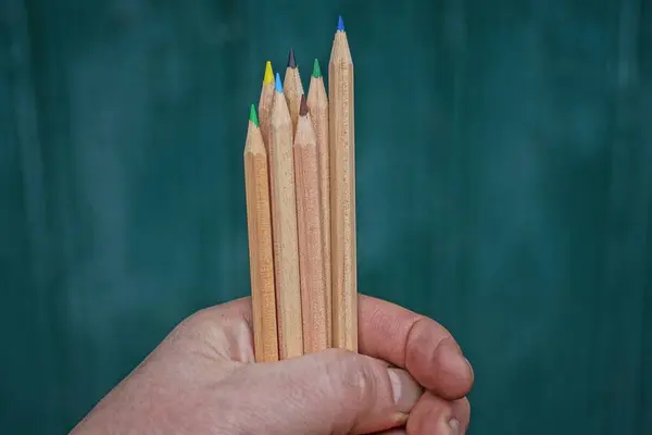 Hand Hält Viele Braune Scharfe Holzstifte Auf Grünem Hintergrund — Stockfoto