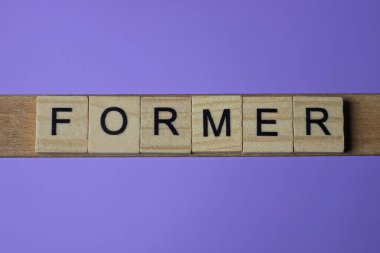 Gri kelime eski küçük kare ahşap harflerle ve eflatun arkaplanda siyah yazı tipiyle