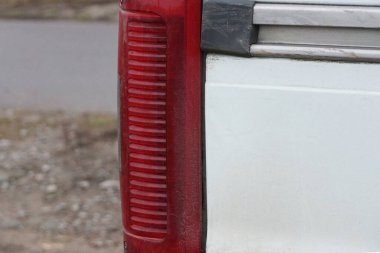 Birinci bölüm, beyaz araba metalinde kırmızı, uzun cam far.