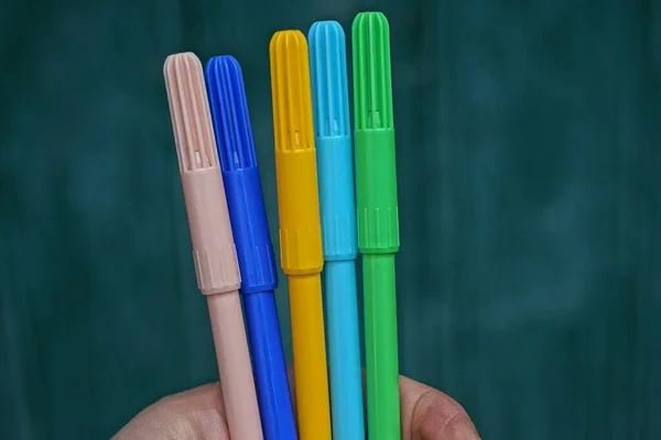 Hand Hält Viele Farbige Plastik Marker Auf Grünem Hintergrund — Stockfoto