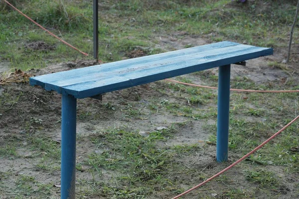 One Empty Blue Wooden Bench Stands Gray Ground Green Grass - Stock-foto