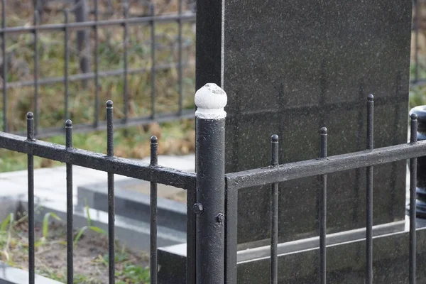 墓地の墓の大理石の記念碑の黒い鉄の棒で作られた装飾フェンスの一部 — ストック写真