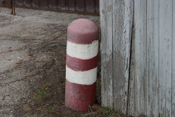 Poste Blanco Rojo Hierro Rayado Levanta Contra Una Cerca Madera —  Fotos de Stock