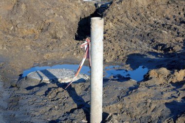 Kahverengi toprakta büyük gri beton boru bacası ve dışarıda çamur.