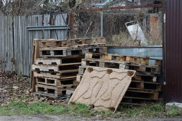 Hög Med Gamla Bruna Träpallar Står Utanför Det Gröna Gräset — Stockfoto