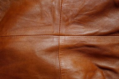 Kahverengi deri desenli, dikişli bir elbise parçası.