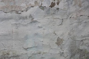 Eski beton duvarda çatlaklar olan eski püskü alçıdan gri beyaz bir doku.