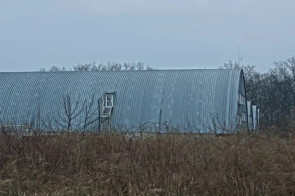 Long Gray Industrial Metal Hangar Brown Dry Grass Sky — Stock Photo, Image