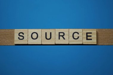 mavi arkaplan üzerinde siyah yazı tipi olan küçük kare tahta harflerle gri sözcük kaynağı