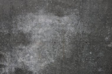 Caddedeki bir çitin içindeki kirli beton duvarın gri beyaz taş dokusu.