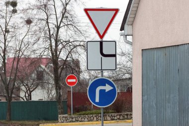 Üç yol işareti caddedeki bir direkte yol ve yön göstergesi veriyor