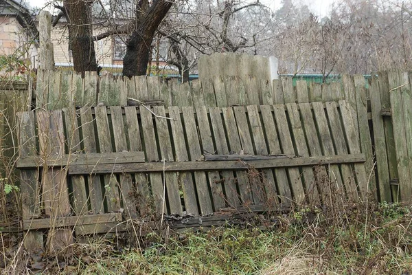 Eski bir kırsal gri çitin bir parçası. Çimlerin üzerinde tahta tahtalardan yapılmış.