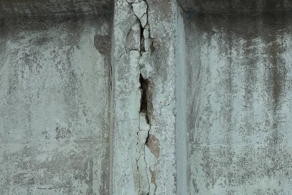 Caddedeki kirli beton duvarda çatlak olan gri taş bir doku.