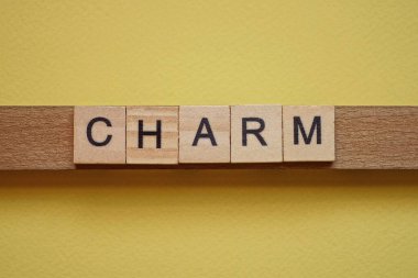 Tahta harflerden yapılmış tılsım sarı bir masada yatıyor.