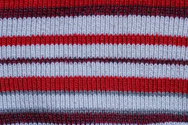 Yünlü kıyafetlerin çizgili beyaz kırmızı kumaşı.