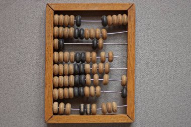 Eski kahverengi ahşap bir abaküs gri bir masada yatıyor.