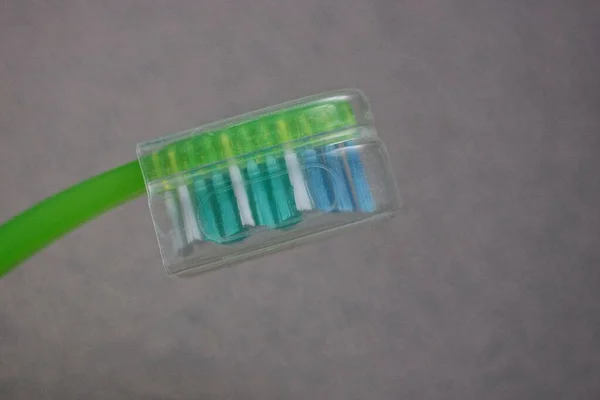 Part Green Toothbrush Colored Bristles Plastic Transparent Cap Gray Background — Stock Photo, Image