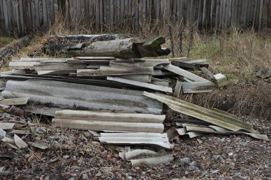 a large pile of rubbish from gray slate pieces of old wooden planks on the street
