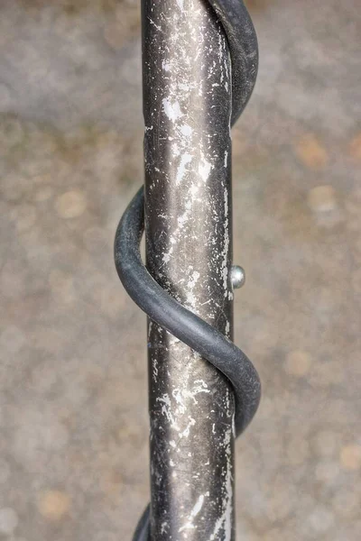 part of a metal detector made of a black metal frayed tube and a wound electric cable on a gray background