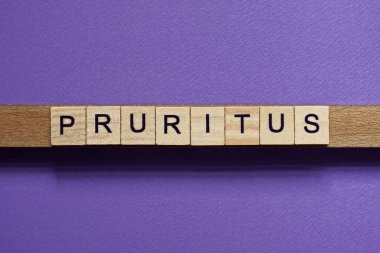 Kahverengi kelime pruritus küçük kare ahşap harflerle ve eflatun arkaplanda siyah yazı tipiyle
