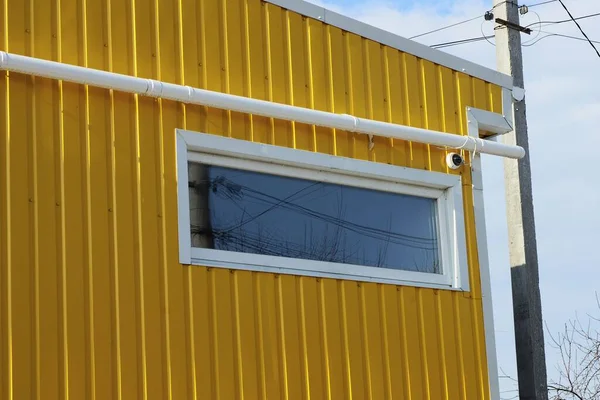 Jedno Bílé Obdélníkové Okno Žluté Kovové Stěně Budovy Plastovou Trubkou — Stock fotografie