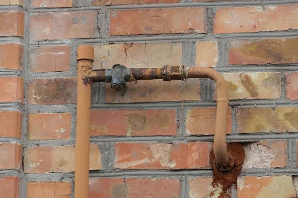 外の茶色のレンガの壁に鉄のガス管 — ストック写真