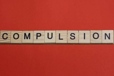 Kırmızı bir masanın üzerinde siyah yazı tipi olan gri ahşap harflerden gelen dürtü sözcüğünü metin