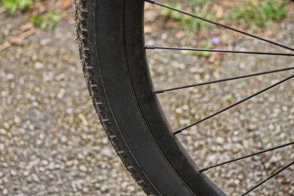 灰色の背景に黒いゴム製のタイヤと金属製のスポークの車輪の一部が — ストック写真