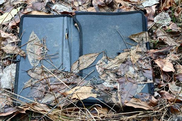 Śmieci Jednego Starego Czarnego Plastikowego Folderu Leżą Ziemi Brązowych Opadłych — Zdjęcie stockowe