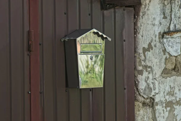 Egy Fehér Vas Postaláda Lóg Egy Barna Fém Kerítés Falán — Stock Fotó