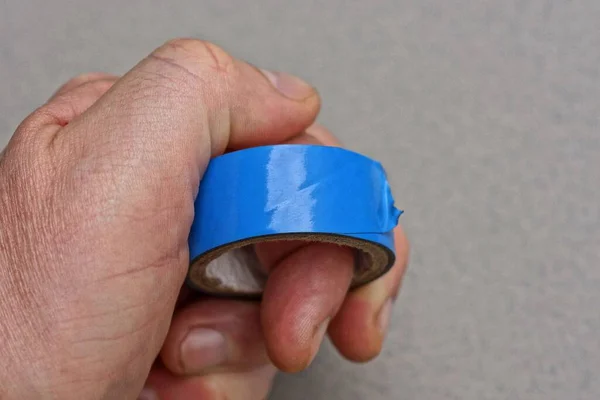 Голубая Круглая Пластиковая Лента Пальцах Сером Фоне — стоковое фото
