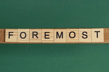 Yeşil bir masadaki küçük ahşap harflerden oluşan gri bir kelime.