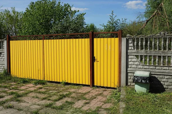 Yellow Metal Gate Closed Door Part Gray Concrete Fence Green — Stock Photo, Image