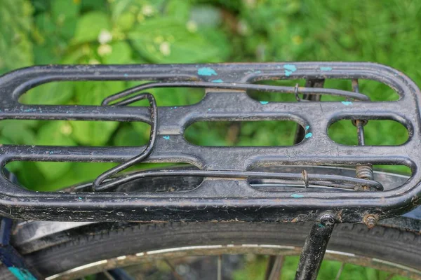 一辆旧式复古自行车的一部分 它是用黑色铁制行李箱盖在一个绿色背景的车轮上制成的 — 图库照片
