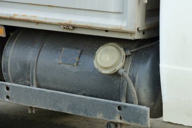 Gri bir otomobil kamyonunda büyük gri bir benzin deposu var.