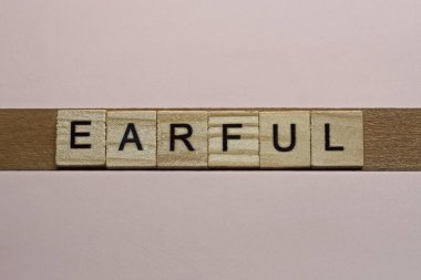 Pembe bir masanın üzerinde siyah yazı tipi olan gri ahşap harflerden 