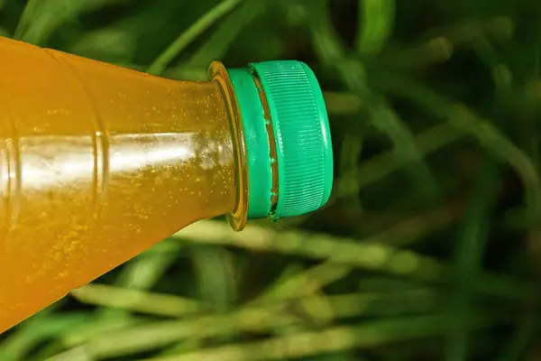 Bottiglia Plastica Chiusa Piena Limonata Gialla Sullo Sfondo Erba Verde — Foto Stock