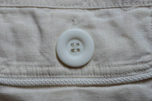 Jeden Duży Plastikowy Biały Przycisk Szarym Materiale Ubraniu — Zdjęcie stockowe
