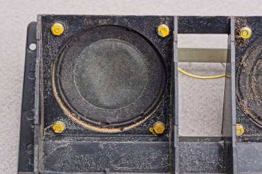 Bozuk bir elektrikli aletin üstünde kirli siyah bir hoparlör.
