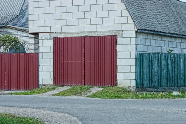 Garajın Beyaz Tuğlalı Cephesinde Kırmızı Metal Kapılar Gri Asfalt Yolun — Stok fotoğraf