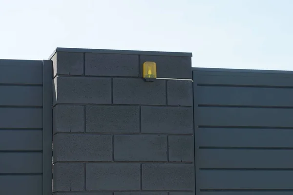 Jedno Žluté Signální Světlo Visící Černé Cihlové Zdi Plotu Ulici — Stock fotografie