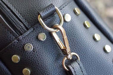 Gri metal karabinalı, siyah deri kemerli bir yüzük.