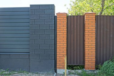 Metal ve tuğladan yapılmış bir çitin siyah kahverengi duvarı