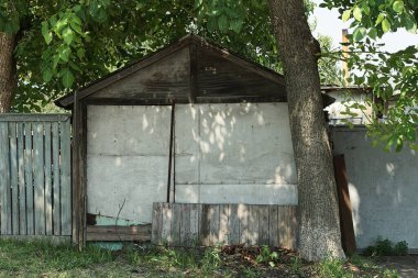 Eski bir ahırın gri ahşap duvarı ve kırsal bir sokakta çitin bir parçası.