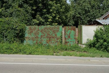 Kahverengi pas ve bitkilerle kaplı eski büyük demir yeşil kapılar